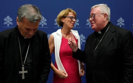 Helena Jeppesen Spuhler, center, talks with Cardinal Jean-Claude Hollerich, right, and Secretary General of the Synod of Bishops Cardinal Mario Grech at the end of a presentation of the new guidelines for the Synod of Bishops at the Vatican June 20. (AP/Domenico Stinellis)