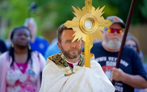 Auxiliary Bishop Andrew Cozzens of St. Paul and Minneapolis carries the Eucharist in a monstrance during a procession June 19, 2021. Cozzens, now bishop of the Diocese of Crookston, Minnesota, is the lead organizer of the National Eucharistic Revival. (OSV News/CNS file/The Catholic Spirit/Dave Hrbacek)