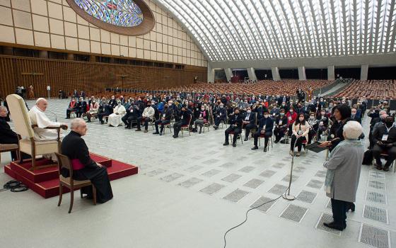 Pope Francis listens as Margaret Karram, the then-new president of the Focolare movement, speaks during an audience with participants in the general assembly of the Focolare movement, in the Paul VI hall Feb. 6, 2021, at the Vatican. The pope encouraged the movement to continue to grow in dialogue with the world today. (CNS/Vatican Media)