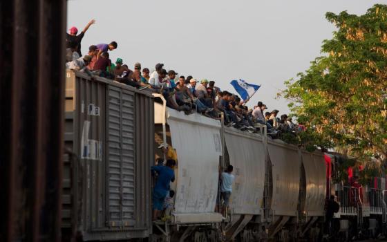 Central American migrants ride atop a freight train during their journey toward the U.S.-Mexico border, in Ixtepec, Oaxaca State, Mexico.