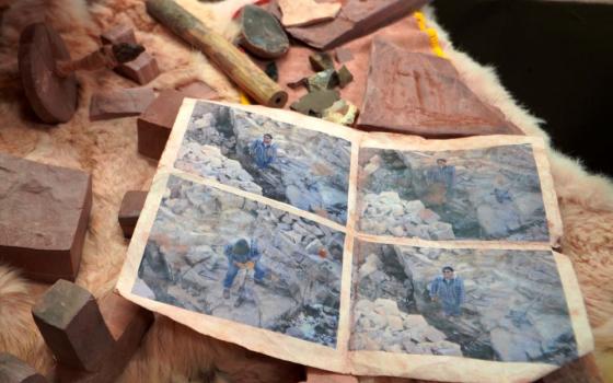 Mark Pederson "Swift Horse," a member of the Sisseton-Wahpeton Dakota Nation and a fourth generation quarrier, shows old photographs of himself digging at his family's quarry at the Pipestone National Monument Museum on Wednesday, May 3, 2023, in Pipestone, Minn.