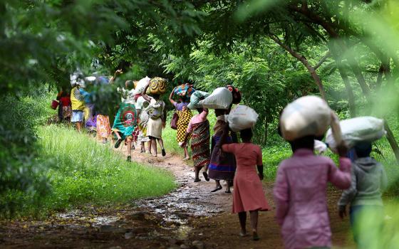 Flood victims from Mtauchira village carry food they received from the Malawi government in Blantyre March 16 in the aftermath of Cyclone Freddy, which destroyed their homes. (OSV News/Reuters/Esa Alexander)