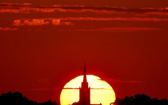 A church is pictured at sunset during a heat wave in Sancourt, France, July 12, 2023. A blistering and deadly heat wave is sweeping Europe, potentially bringing record-breaking temperatures and raising serious concerns about the impacts on people’s health, especially as the continent welcomes an influx of tourists. (OSV News/Reuters/Pascal Rossignol)