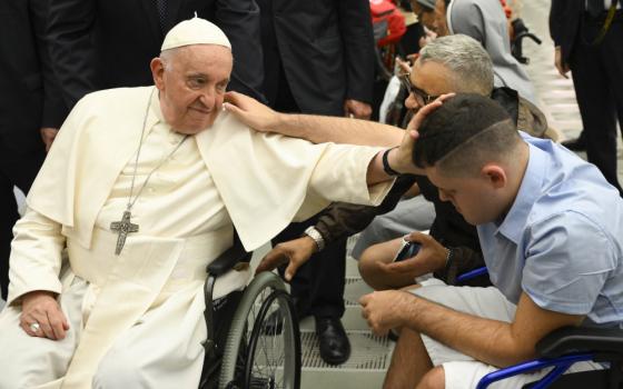  Pope Francis, seated in his wheelchair, blesses a young man seated in a wheelchair at the end of his weekly general audience Aug. 9, 2023, in the Vatican audience hall. (CNS photo/Vatican Media)