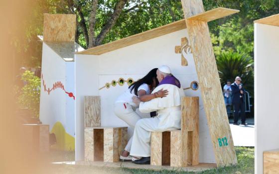 Pope Francis embraces a World Youth Day pilgrim after hearing her confession in Vasco da Gama Garden in Lisbon, Portugal, Aug. 4. The pope administered the sacrament to three pilgrims: young men from Italy and Spain, and the young woman from Guatemala. (CNS/Vatican Media)