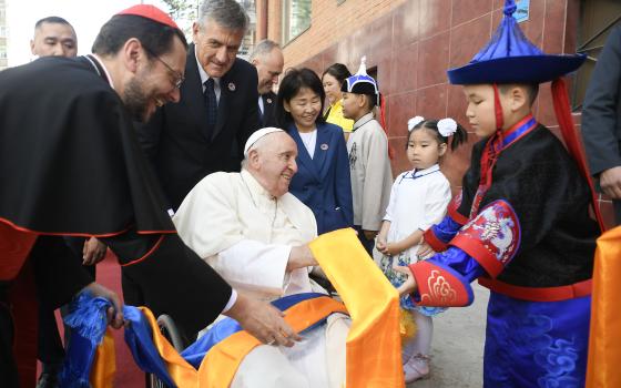 A boy gives Pope Francis scarves as he arrives at the headquarters of the Apostolic Prefecture of Ulaanbaatar, Mongolia, Sept. 1, 2023. Cardinal Giorgio Marengo, the prefect, will host the pope at the prefecture during his four-day visit to the country. (CNS photo/Vatican Media)
