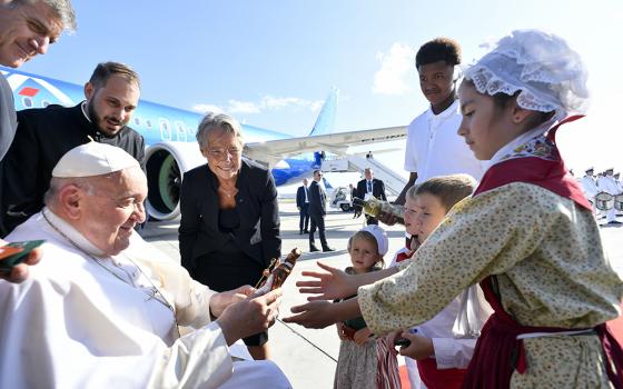 Four children and a young man give Pope Francis gifts while French Prime Minister Élisabeth Borne looks on during a brief welcoming ceremony at Marseille International Airport Sept. 22 in Marseille, France. (CNS/Vatican Media)