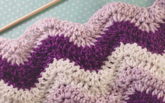 Pink, purple and white afghan blanket (Dreamstime/Jessicacasetorres)
