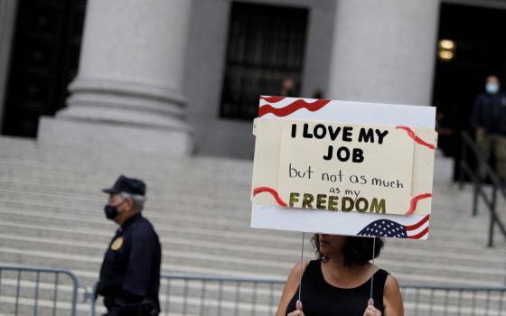 A woman in New York City holds a sign Oct. 12, 2021, during a protest over the city's COVID-19 vaccine mandate.