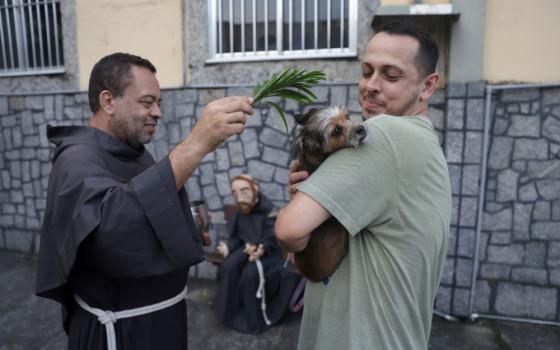 A priest blesses a dog outside a church during a prayer service for blessing of the animals in Rio de Janeiro Oct. 4, 2023, the feast of St. Francis of Assisi, patron of animals. (OSV News photo/Pilar Olivares, Reuters)