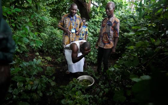 A voodoo worshiper washes his face after visiting the Bohouezoun sacred forest in Benin, on Thursday, Oct. 5, 2023. As the government grapples with preserving the forests while developing the country, Voodoo worshippers worry the loss of its spaces could have far reaching effects. (AP/Sunday Alamba)