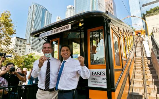 José Huizar, right, then a Los Angeles council member, is pictured with L.A. Mayor Eric Garcetti showing their Metro cards as they ride the Angels Flight Aug. 31, 2017.