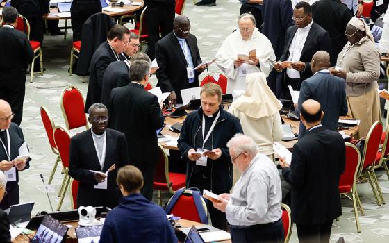 Members of the assembly of the Synod of Bishops pray before a working session in the Vatican's Paul VI Audience Hall Oct. 26. (CNS/Lola Gomez)