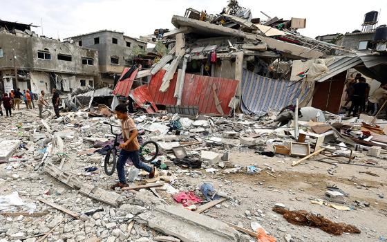 A child walks at the site of an Israeli air strike on a house in Khan Younis in the southern Gaza Strip Oct. 27 as the conflict between Israel and Palestinian Islamist group Hamas continues. (OSV News/Reuters/Mohammed Salem)