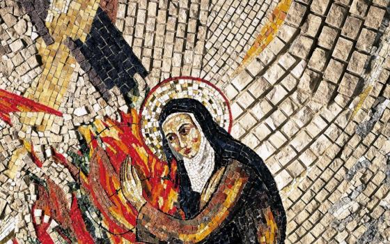 A mosaic featuring a woman wearing a white coif and black veil with arms around flames