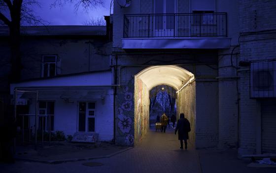 People walk through an alleyway at dusk in central Kyiv, Ukraine, Nov. 18. (AP/Felipe Dana)