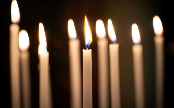 Nine lit candles in darkness