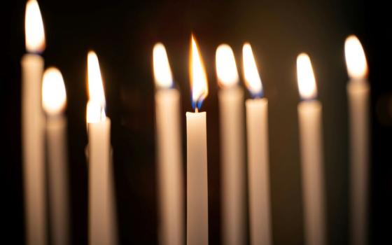Nine lit candles in darkness