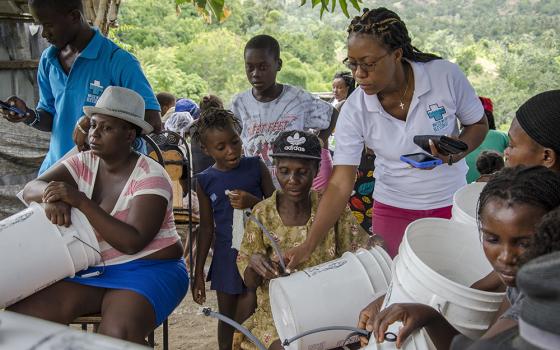 A Water With Blessings teacher in Anse-a-Veau, Haiti, collects GIS data and checks on hardware installation at the end of a 2018 training. (CNS/Courtesy of Water With Blessings/Corey Ohlenkamp) 