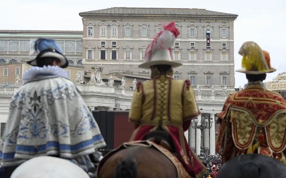 Participants in a parade for the feast of the Epiphany attend Pope Francis' recitation of the Angelus from the window of his studio overlooking St. Peter's Square Jan. 6, 2023, at the Vatican. (CNS/Vatican Media)