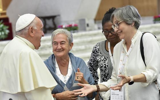 Pope Francis shares a laugh with some of the women members of the assembly of the Synod of Bishops, including Spanish theologian Cristina Inogés Sanz, left, at the assembly's session Oct. 6 in the Paul VI Audience Hall at the Vatican. (CNS/Vatican Media)