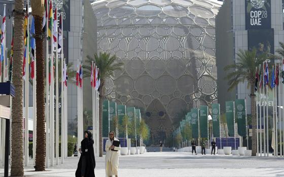 People walk through the COP28 U.N. climate summit Dec. 13 in Dubai, United Arab Emirates. (AP photo/Peter Dejong)