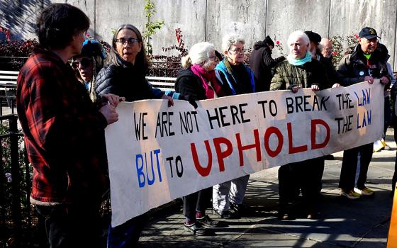 A group of Catholic activists block the entrance to the United States Mission to the United Nations in New York City on Nov. 30. (Felton Davis)