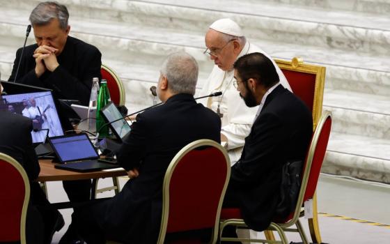 Four men at a table  including Pope Francis and Bishop Daniel Flores.