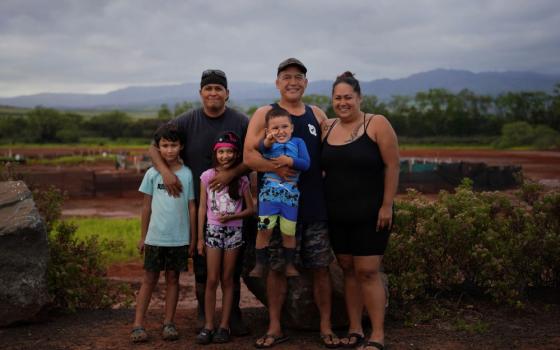 Kurt Kuali'i, father of Elijah Kuali'i and Arianna Kuali'i, stands with his fellow salt makers, Ivan Kaneko, Tanya Kaneko and their son Taivan Kaneko, for a portrait in front of the Hanapepe salt patch on Thursday, July 13, 2023, in Hanapepe, Hawaii. (AP Photo/Jessie Wardarski)