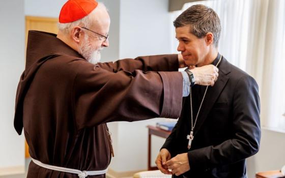 Cardinal Seán O'Malley of Boston gives Bishop-designate Cristiano Barbosa his pectoral cross at the Archdiocese of Boston's pastoral center in Braintree, Mass., on Dec. 9.