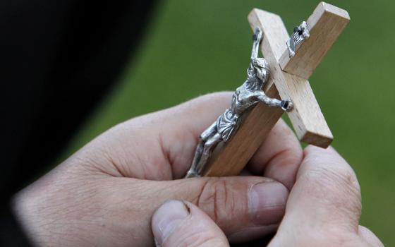 A woman holds a crucifix in this 2010 file photo. (CNS/Reuters/Vasily Fedosenko)