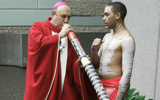 Bishop Christopher Saunders of Broome tries to play a didgeridoo during a World Youth Day media event in Sydney, Australia, on April 17, 2008. Saunders, a retired Catholic bishop, has been charged Feb. 22, 2024, with child sex abuse offenses in a remote part of Australia's northwest. (AP/Rob Griffith, File)