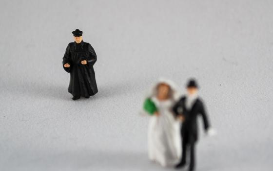 Figurines of a priest and a bride and groom (Dreamstime/3dm1983)