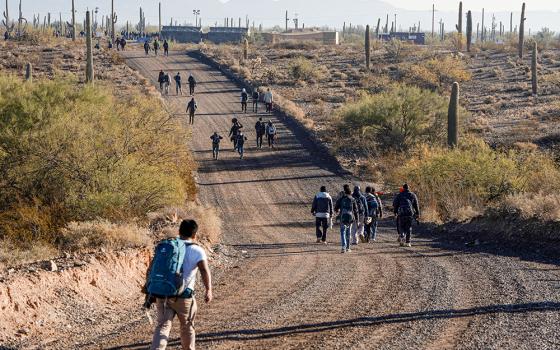 Migrants walk to a processing facility as directed by Border Patrol at the U.S.-Mexico border near Lukeville, Arizona, Dec. 25, 2023. (OSV News/Reuters/Rebecca Noble)
