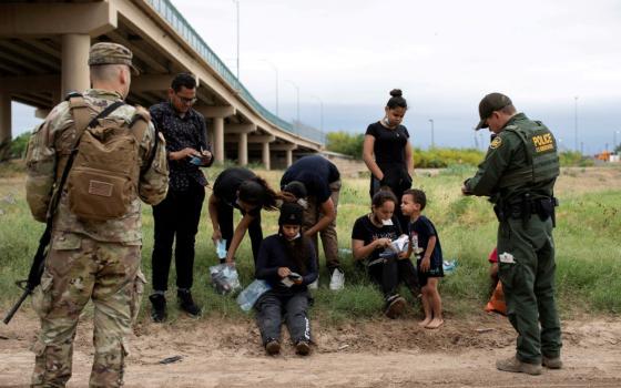 A Customs and Border Protection agent near the southern border town of Eagle Pass, Texas, collects biographical information from a group of Venezuelan migrants April 25, 2022, before taking them into custody. In recent mont