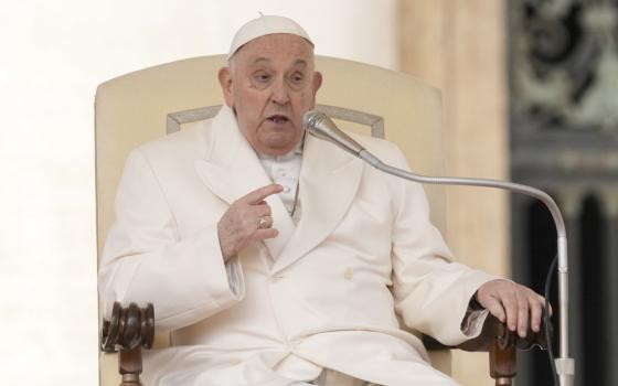 Pope Francis sits while delivering address at General Audience