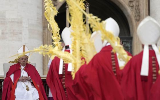 Pope Francis seated, vested for Mass, Bishops process with palms in foreground