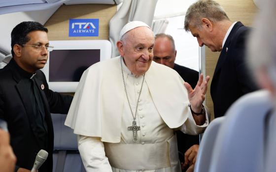 Pope Francis greets journalists aboard his flight back to Rome from Ulaanbaatar, Mongolia, Sept. 4, 2023, after his four-day visit to the Asian country. (CNS photo/Lola Gomez)