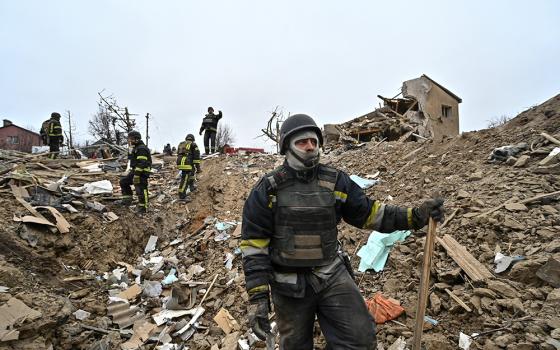 A first responder works at a site of residential buildings destroyed by a Russian airstrike in Zaporizhzhia, Ukraine, March 22, 2024. (OSV News/Reuters)