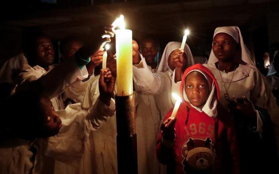 Worshippers light the paschal candle during the Easter Vigil at the St. Joanes, Legio Maria of African Church Mission within Fort Jesus in Kibera district of Nairobi, Kenya, March 30. (OSV News/Reuters/Monicah Mwangi)