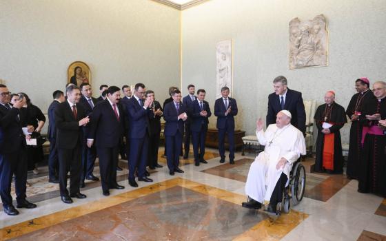 Pope Francis at guests from wheelchair