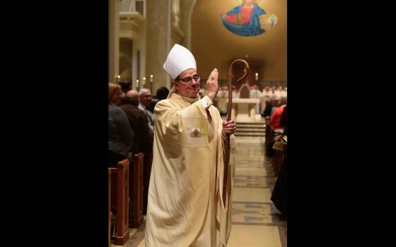 Bishop Power, vested with crozier, blesses assembly. 