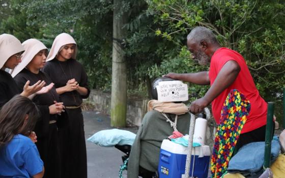 Sisters Poor of Jesus Christ pray with a man during their street ministry in Cedartown, Georgia.