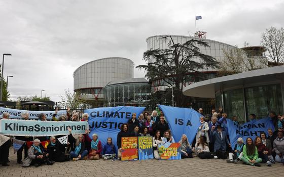 People demonstrate outside the European Court of Human Rights April 9, in Strasbourg, eastern France. The European Court of Human Rights handed down decisions in a trio of cases brought by a French mayor, six Portuguese youngsters and over 2,000 Swiss women who said their governments are not doing enough to combat climate change. (AP photo/Jean-Francois Badias)
