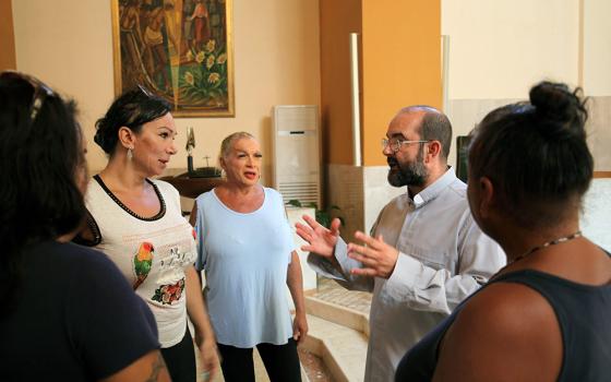 The Rev. Andrea Conocchia talks to a small group of trans women at the Church of the Immaculate Blessed Virgin on Sept. 5, 2022, in Torvaianica, Italy. (RNS/Federico Manzoni)