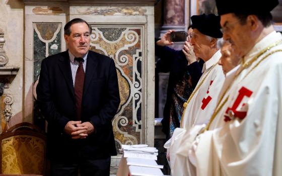 Donnelly stands, hand folded, as prelates say Mass. 