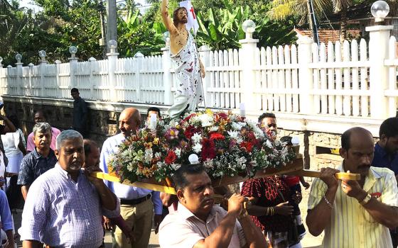 Family members who lost their loved ones during the 2019 Easter bomb attacks carry the bloodstained statue of the risen Christ in the Easter profession March 31 at St. Sebastian's Church, Katuwapitiya, Sri Lanka. (Thomas Scaria)