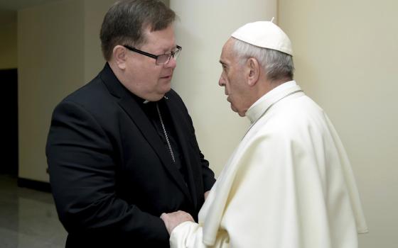 Pope Francis faces Cardinal La Croix, with hand on arm, in conversation. 