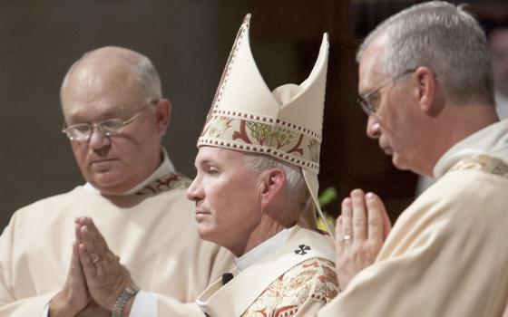 Archbishop Lucas, vested, says Mass. Pictured in profile. 