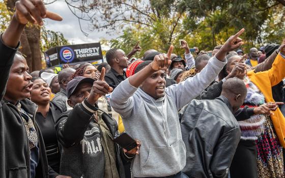Opposition supporters protest outside a court in Harare, Zimbabwe,, June 27. The protesters were angered by a magistrate's decision to deny bail to close to 80 activists arrested mid-June for allegedly meeting without official clearance. (AP/Aaron Ufumeli)